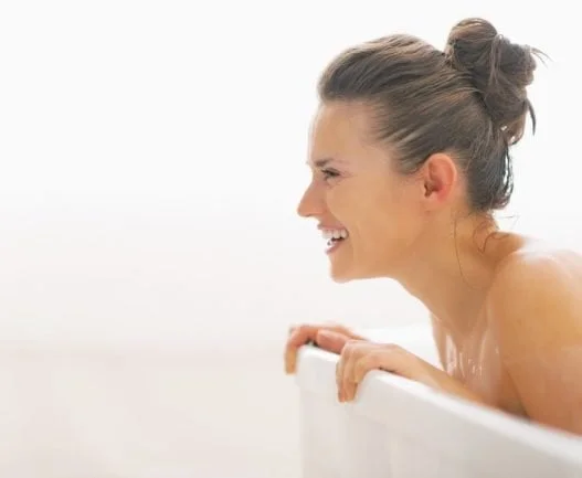 Smilende kvinde i badekar